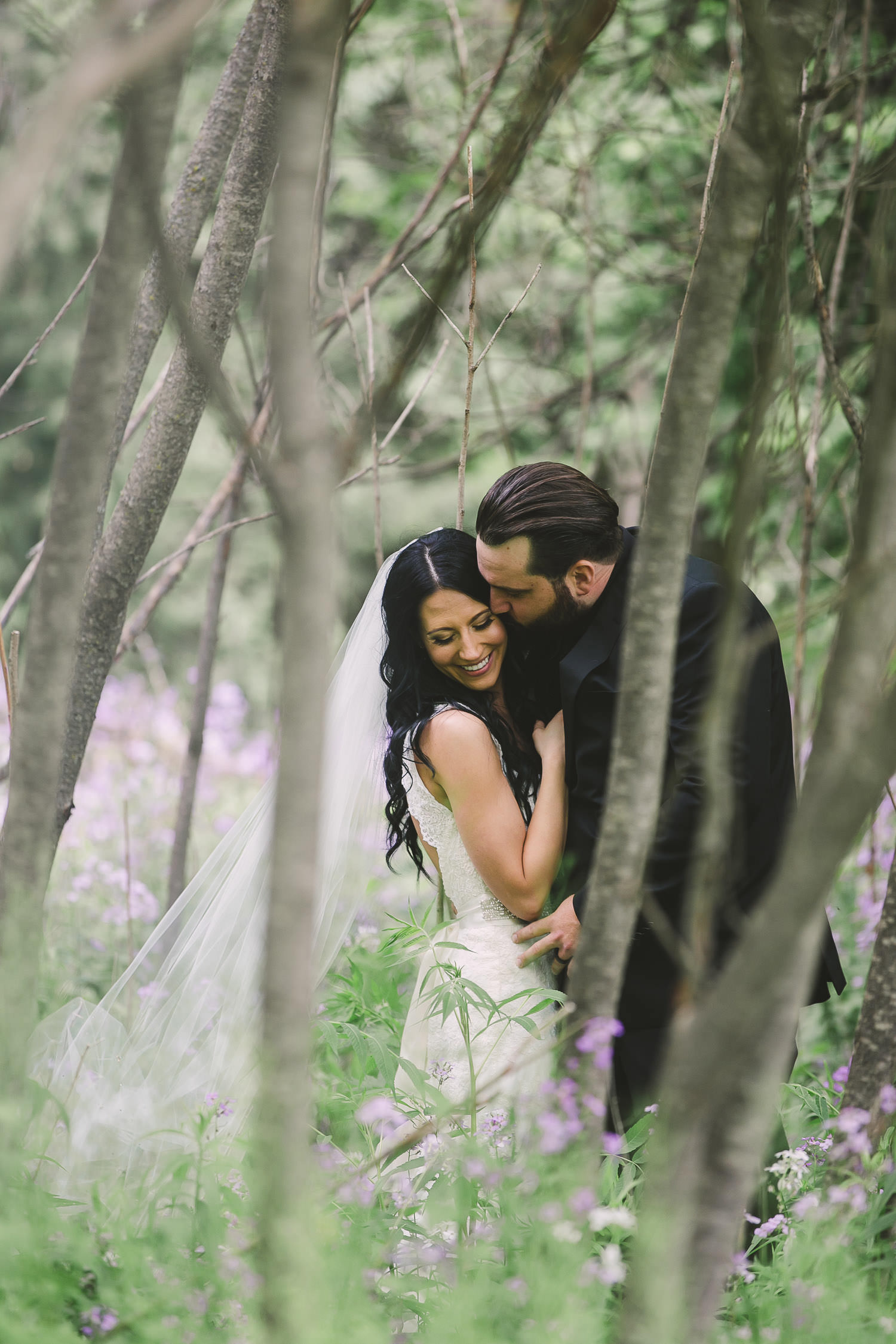 couples steals kiss in wildflowers in rural ontario