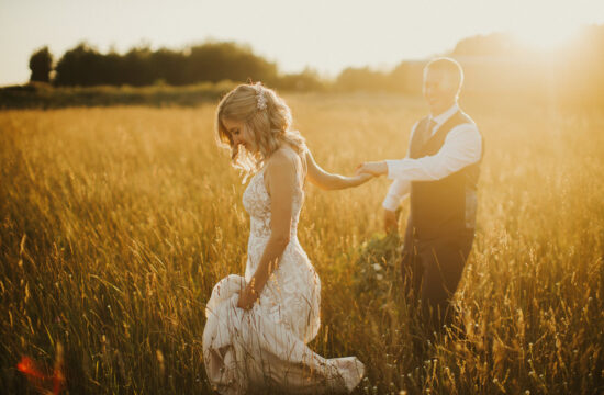 a golden sunset in a field of long grass simple bride and groom beautiufl